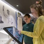 Younger visitors using interactive display in exhibition area